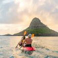A couple rented a kayak and are Kayaking to Chinaman's Hat