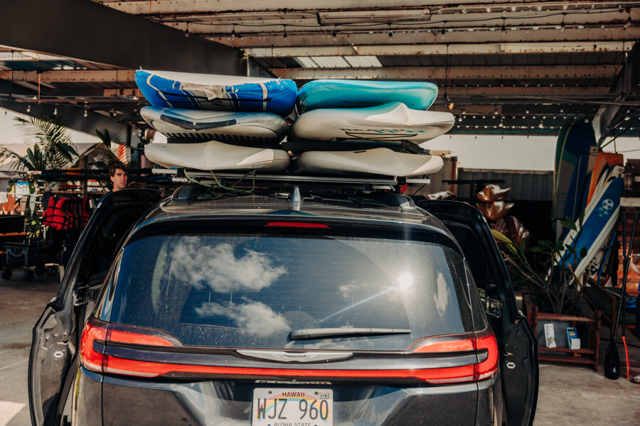 six paddleboards on top of a vehicle