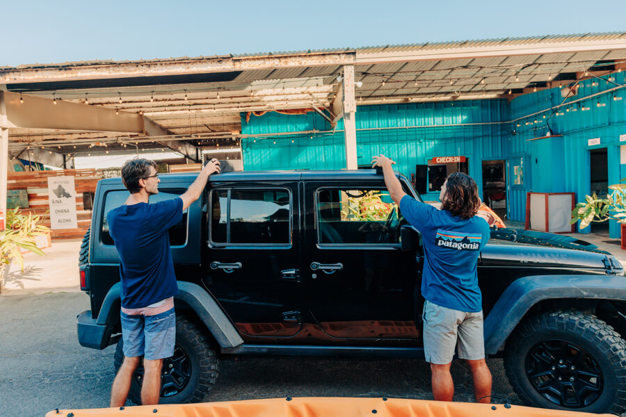 Active Oahu Staff placing foam pads on top of a vehicle