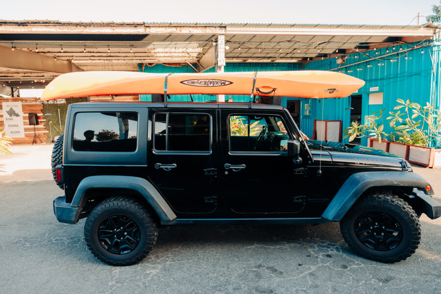 A kayak strapped on top of a vehicle