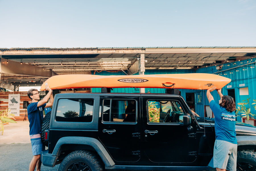 Active Oahu staff lifting a kayak off of a vehicle