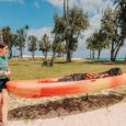 two people carry a kayak to the launch spot of Kailua Beach