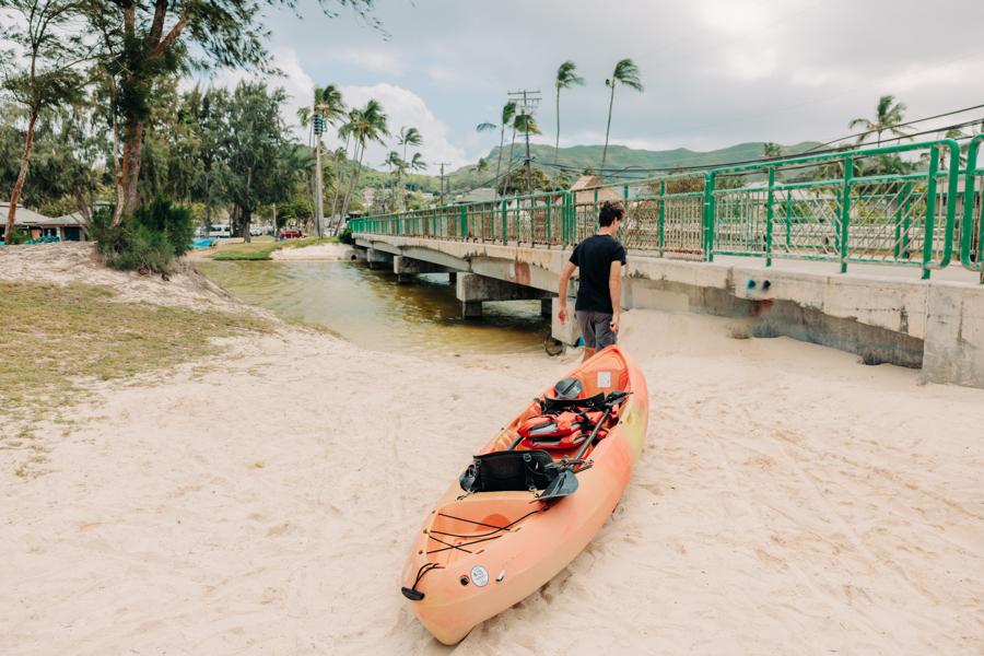 A guy dragging a tandem kayak rental from Active Oahu towards the kayak launch spot