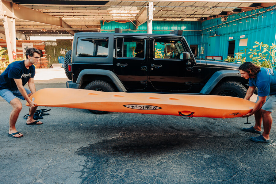 Active Oahu staff setting a kayak onto the ground