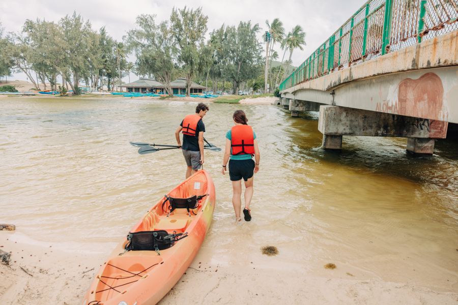 Two people prepare to put a tandem kayak rental from Active Oahu into the water