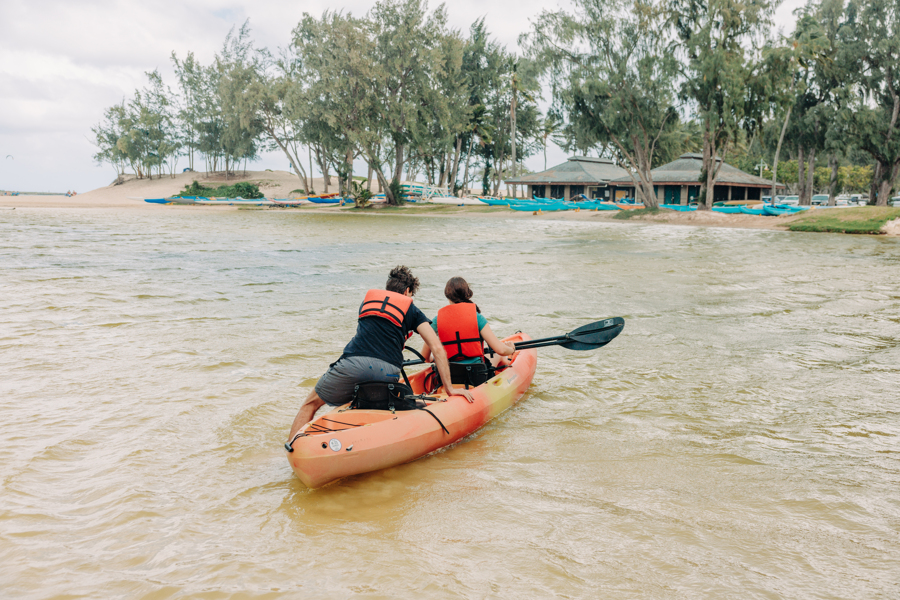 Two people launch into the water with their tandem kayak rental from Active Oahu