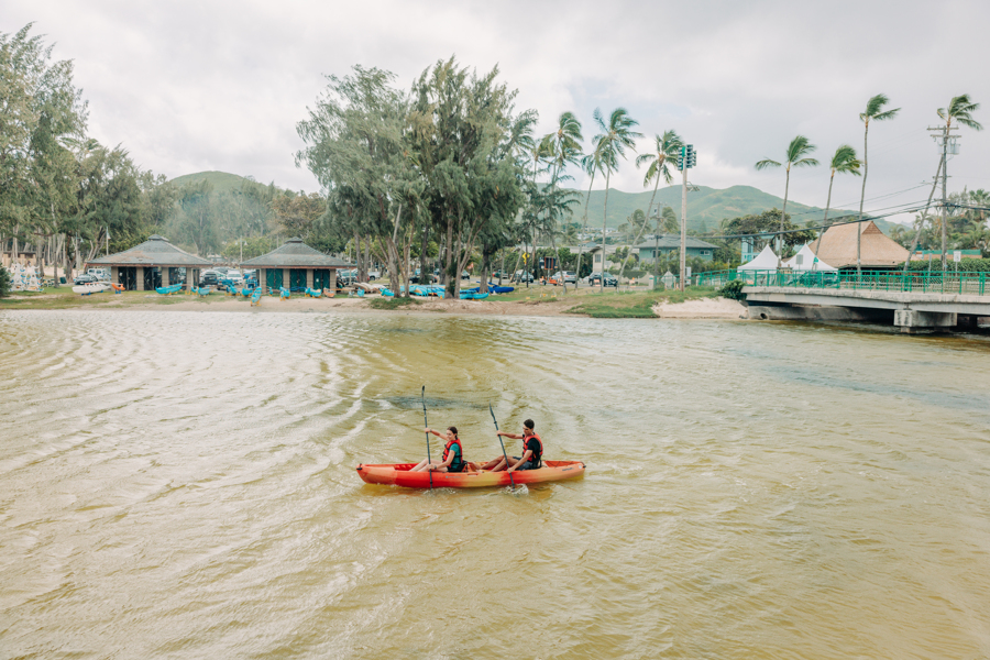 Two people paddle in a canal with their tandem kayak rental from Active Oahu