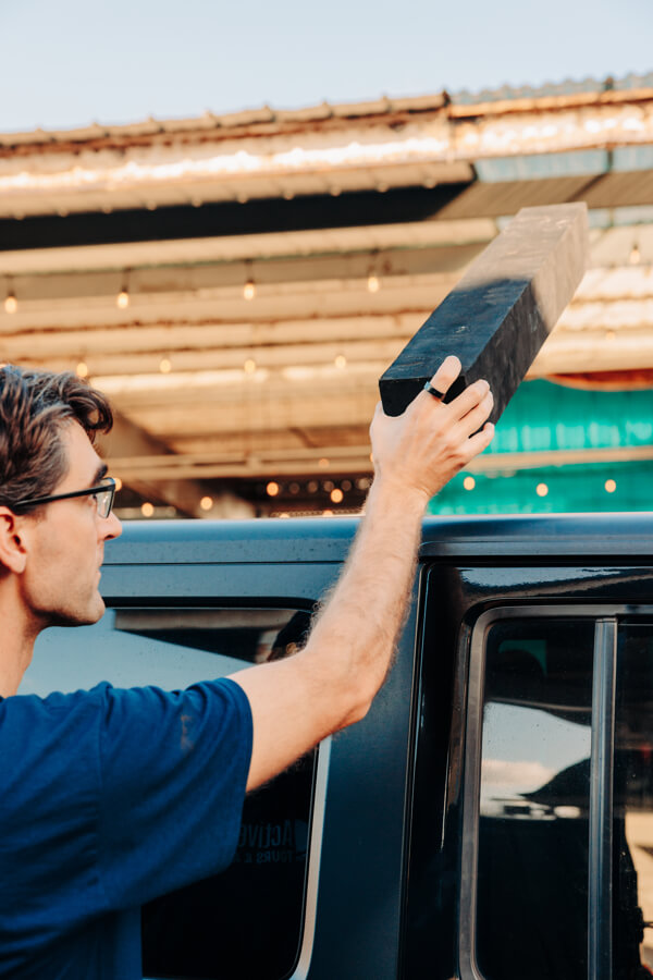Active Oahu staff taking a foam pad off of a vehicle