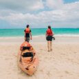 people carry a kayak rental into the water at Kailua Beach