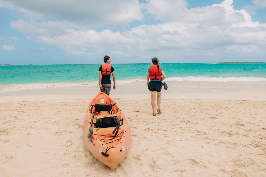 people carry a kayak rental into the water at Kailua Beach