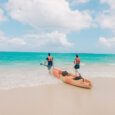 Two people enter the water with a tandem kayak rental from Active Oahu