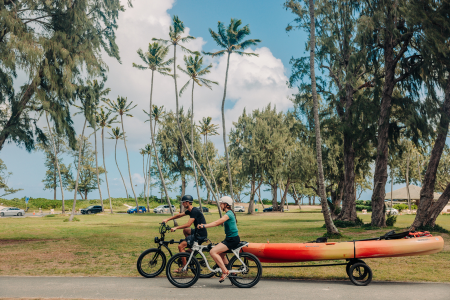 Two people on their e-bike rentals from Active Oahu on a bike path in Kailua