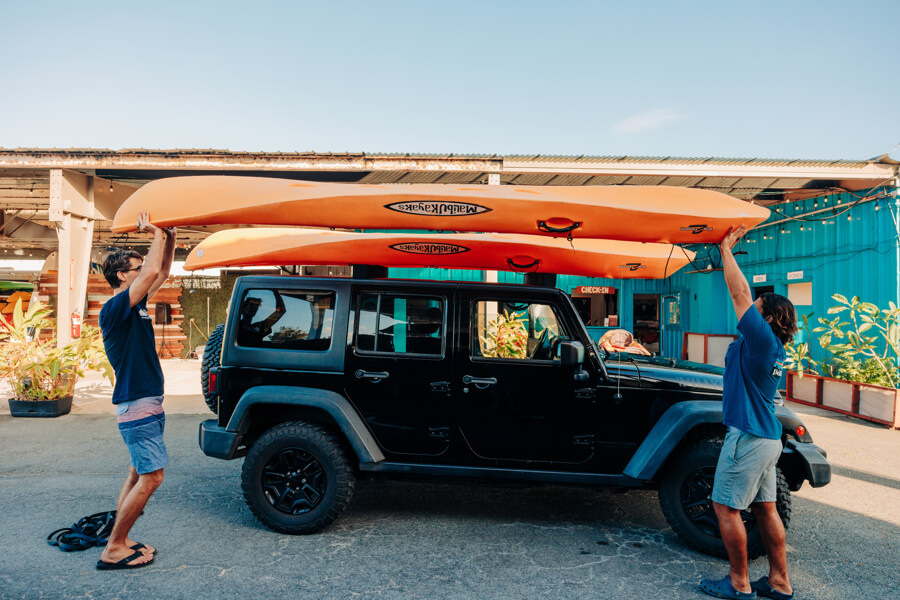 Active Oahu staff lift the kayak above their heads