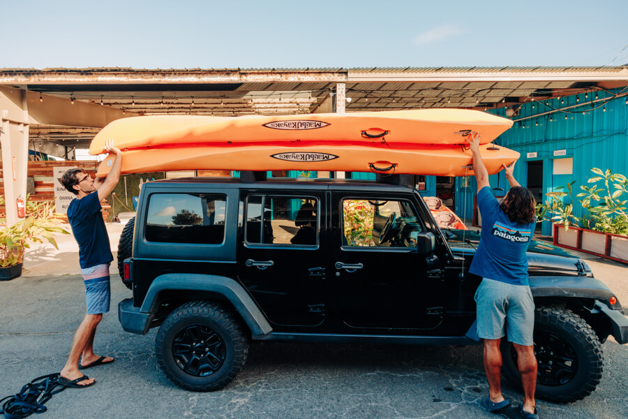 Active Oahu staff place a second kayak on top of the first one on the vehicle