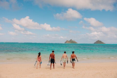 people walk into the waters of Lanikai beach with snorkel gear rentals