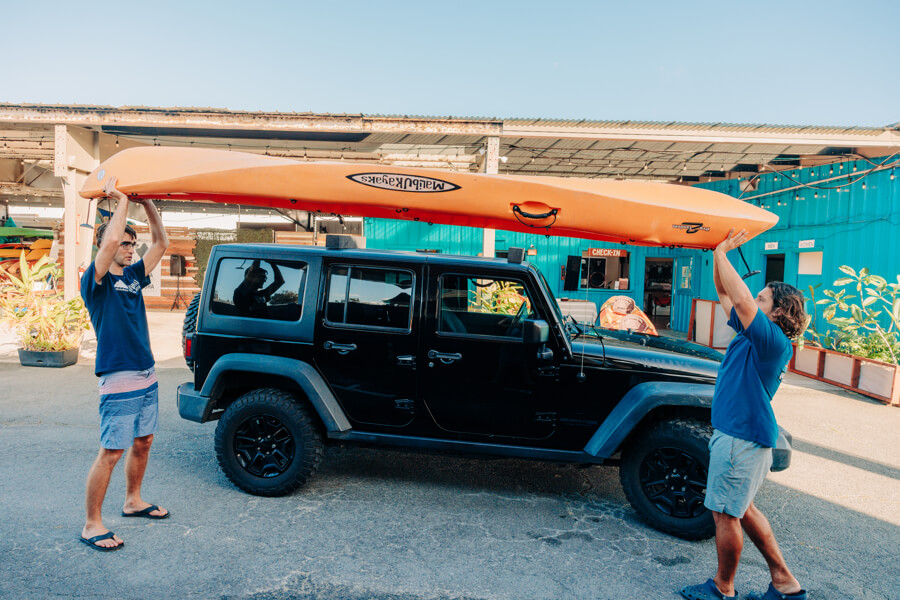 Active Oahu staff lift kayak above their heads