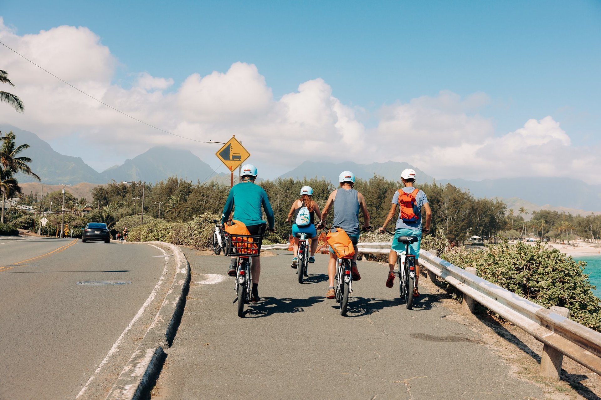 People e-bike on a bike path in Kailua overlooking Lanikai beach