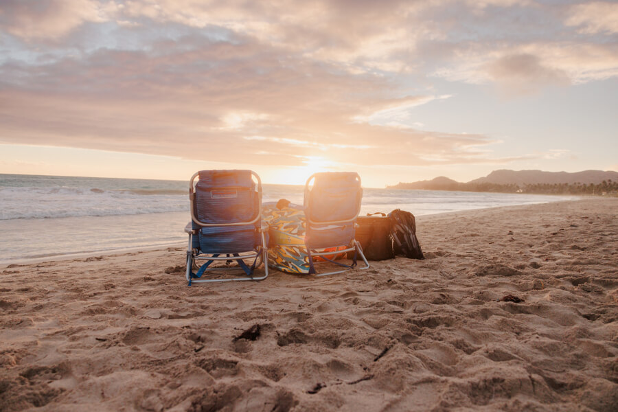 Beach gear rentals from Active Oahu set up on the sand at sunset