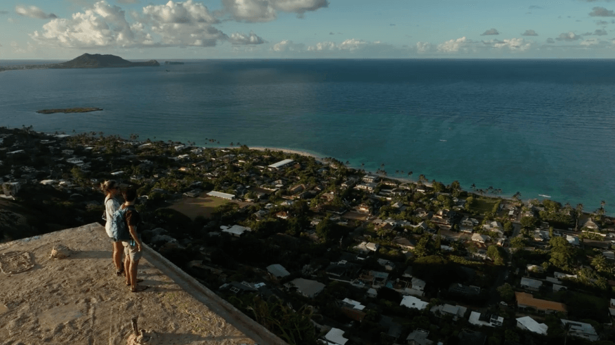 Drone view of two people on top of the Lanikai Pillbox overlooking Lanikai Beach
