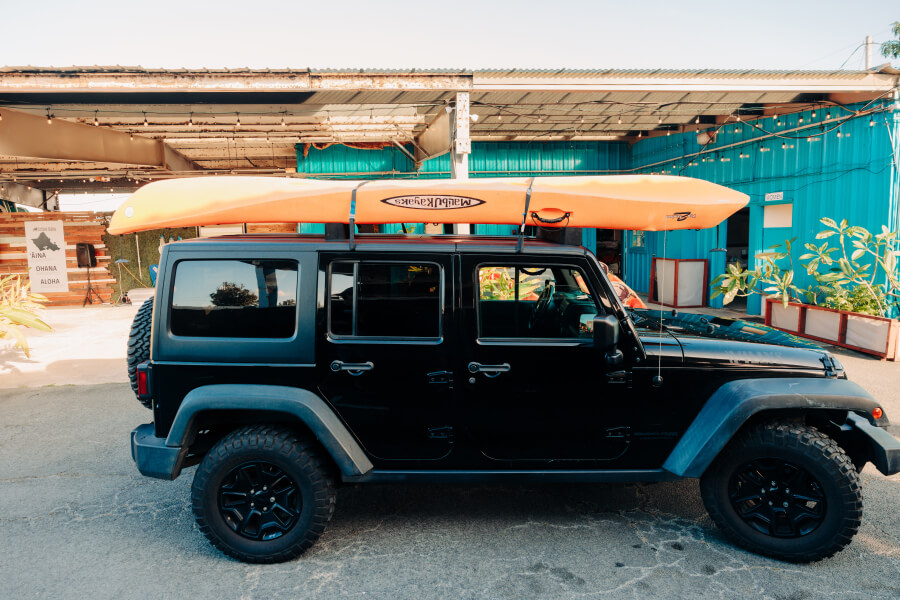 A kayak rental from Active Oahu strapped on top of a jeep