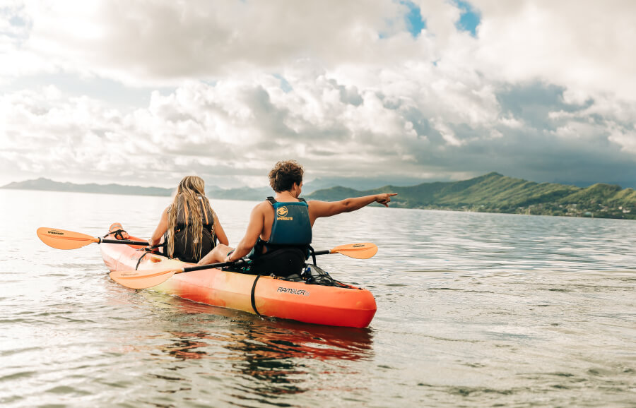 Two people in their tandem kayak rental from Active Oahu paddle in the ocean.