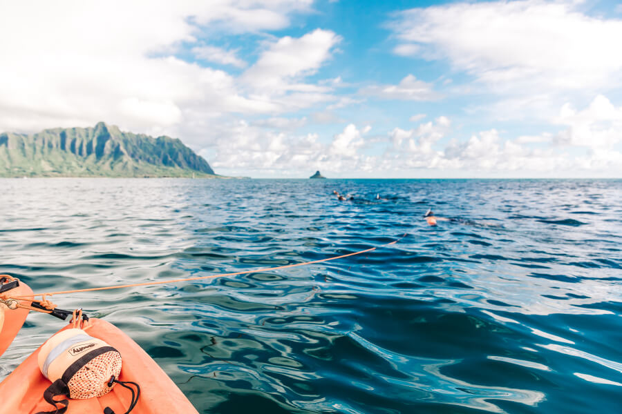 A floating rope kayak anchor a person is holding onto while they snorkel