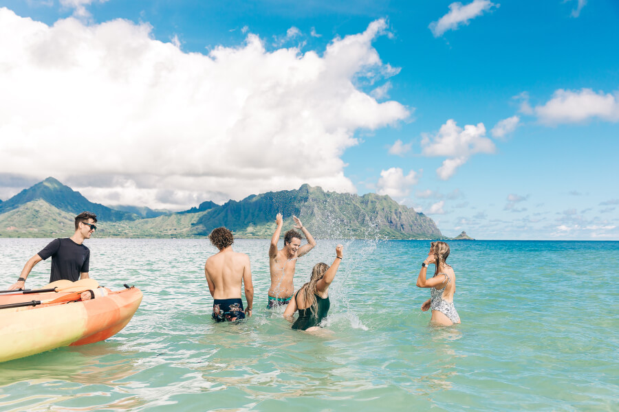A group of people hanging out on the Kaneohe sandbar with their kayak rental from Active Oahu