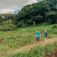 Two people walk along a garden on Oahu