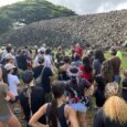 a group of volunteers gathered in front of an ancient Hawaiian temple